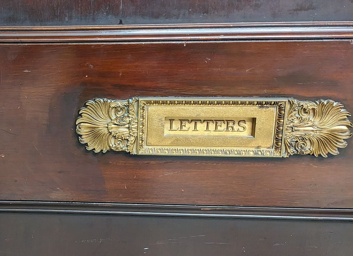 Mosiężna szczelina na listy z napisem „Letters” w drewnianych drzwiach